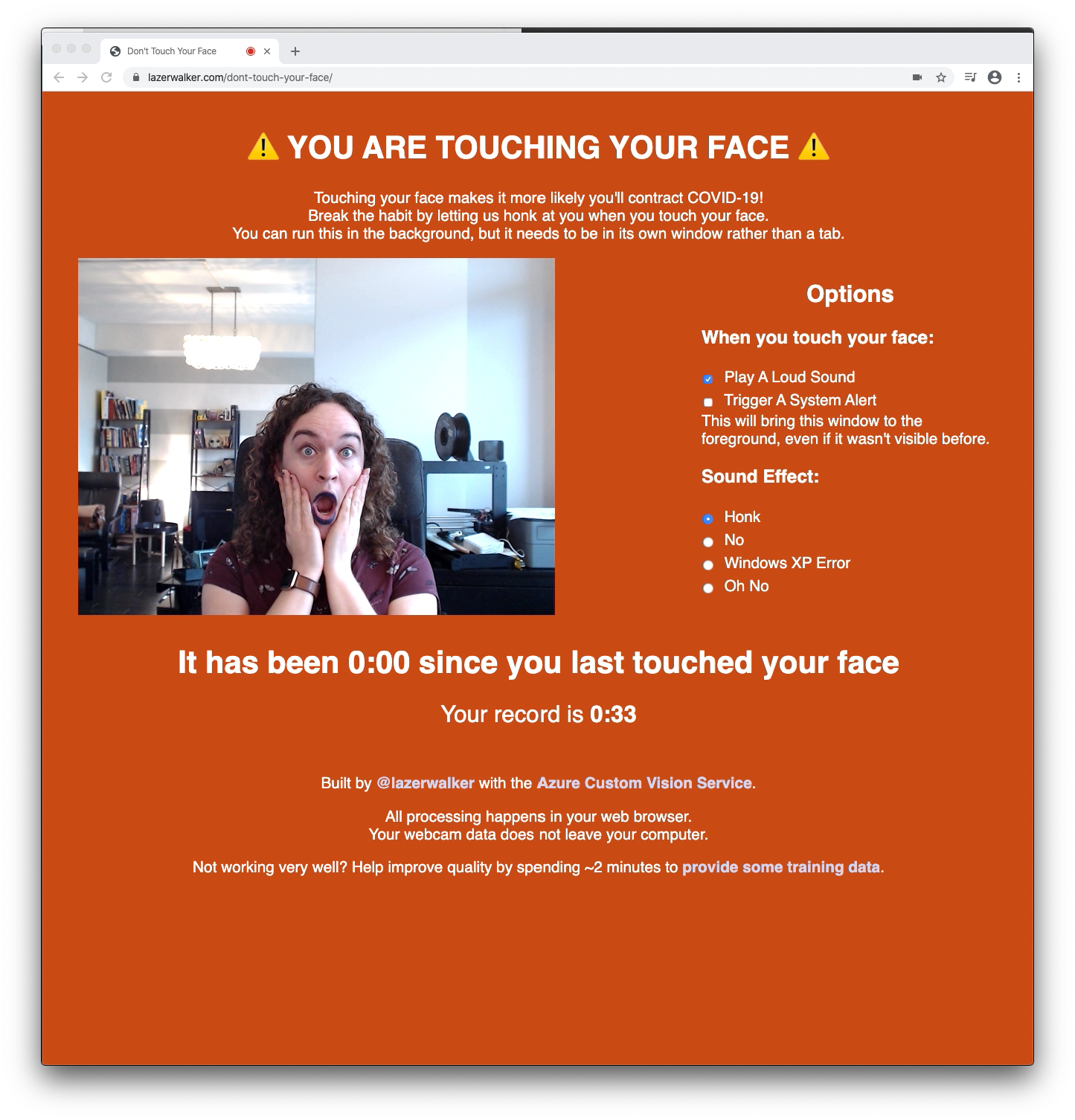 A screenshot of the web app where I am touching my face in the webcam view. The page background is red, and big all-caps text tells me I am touching my face.